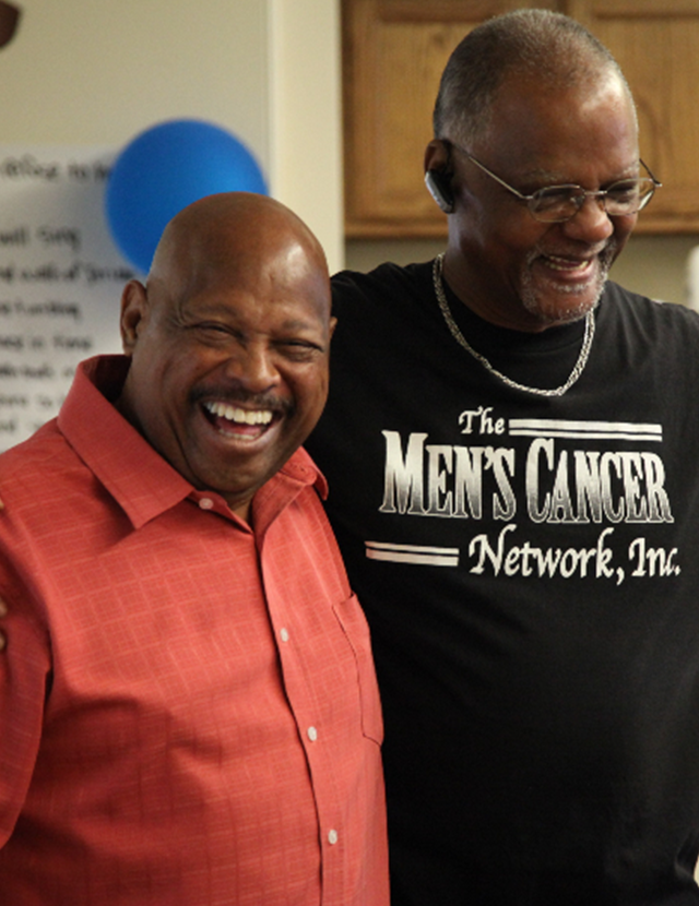 two men smiling wearing a Men's Cancer Network show