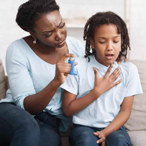 Black mother holding asthma inhaler for daughter⁠