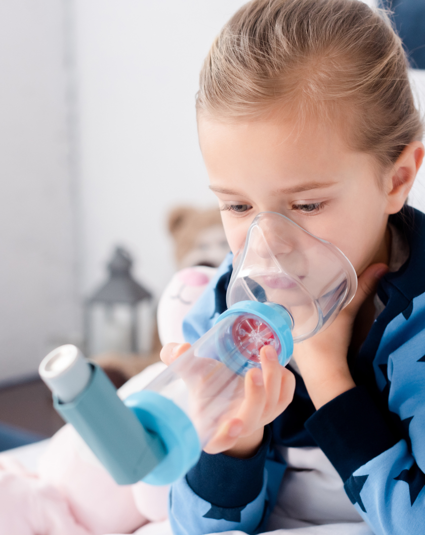 Girl with asthma inhaler and spacer