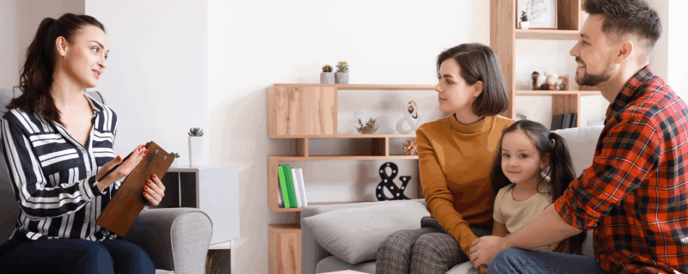 family with visitor holding notepad