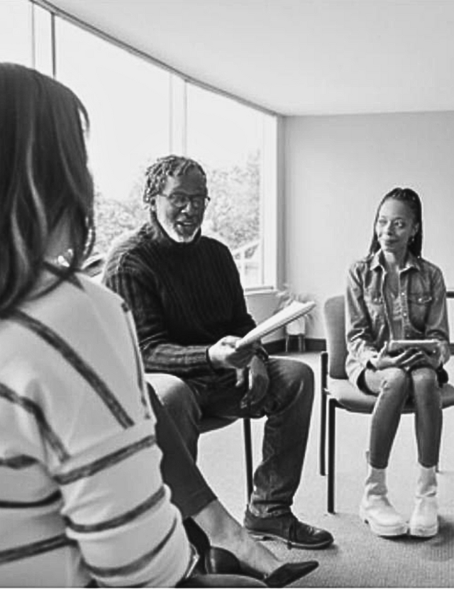 people sitting in a circle holding notepads