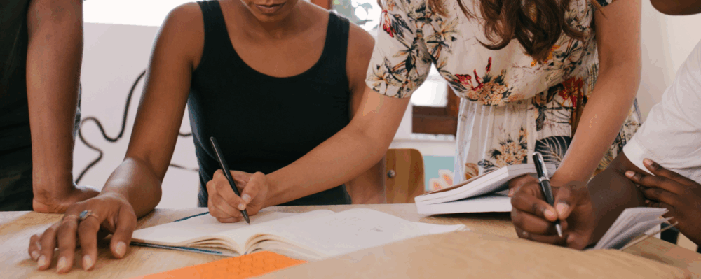 people working together while writing