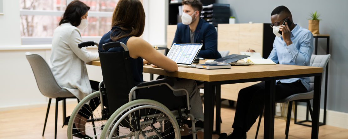 woman in wheelchair working at a table