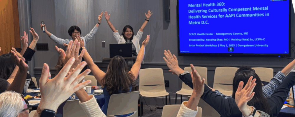 group of people in workshop with arms up in the air