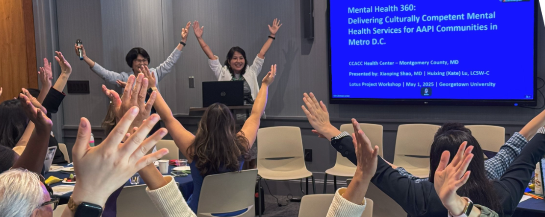group of people in workshop with arms up in the air