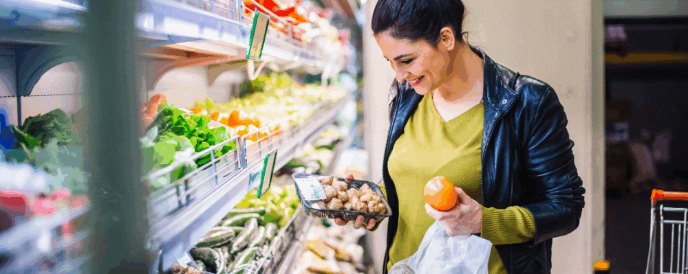 woman buying produce at grocery store