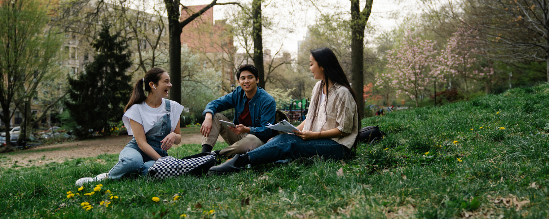 young adults sitting on grass in the park