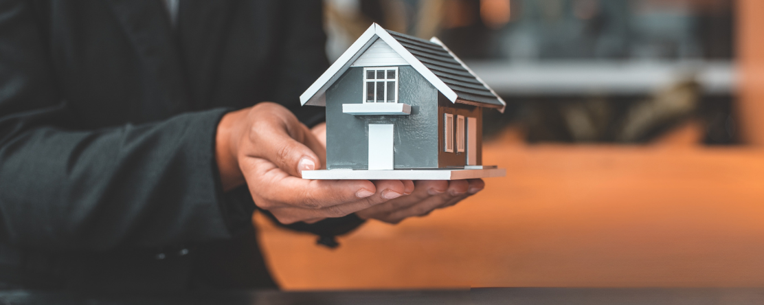 person holding tiny model of a house