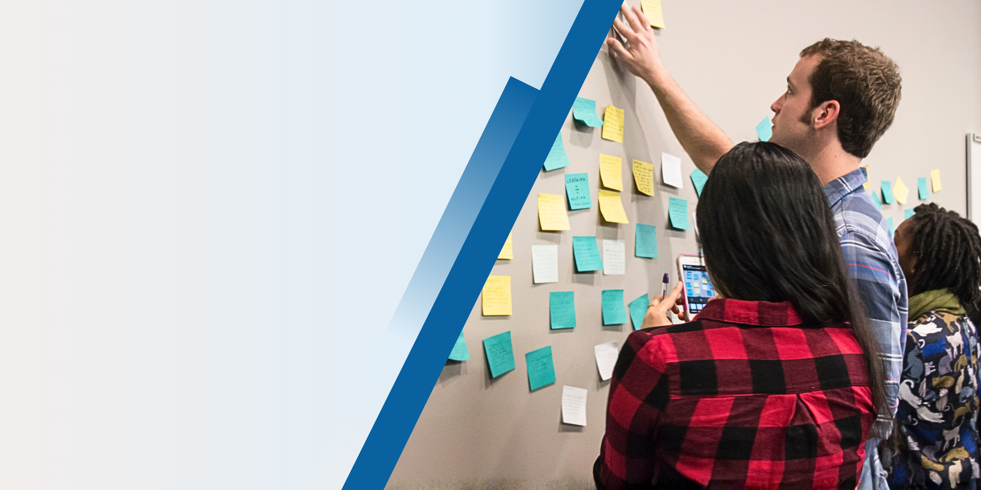 people putting post it notes on board