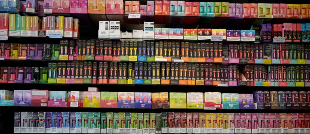 a wall of vapes and other tobacco products with colorful packaging