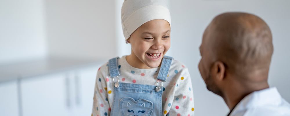 a child with cancer with her doctor