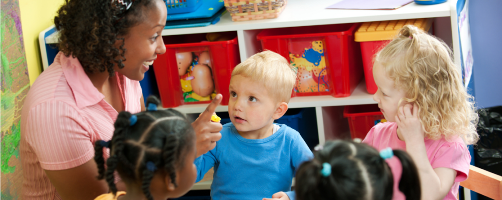 daycare teacher in front of group of children